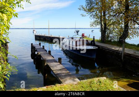 Eine malerische Aussicht mit einem alten Fischerboot auf der Insel Frauenchiemsee oder Fraueninsel auf dem Chiemsee an einem sonnigen Oktobertag in Bayern (Deutschland) Stockfoto