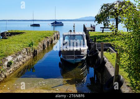 Eine malerische Aussicht mit einem alten Fischerboot auf der Insel Frauenchiemsee oder Fraueninsel auf dem Chiemsee an einem sonnigen Oktobertag in Bayern (Deutschland) Stockfoto