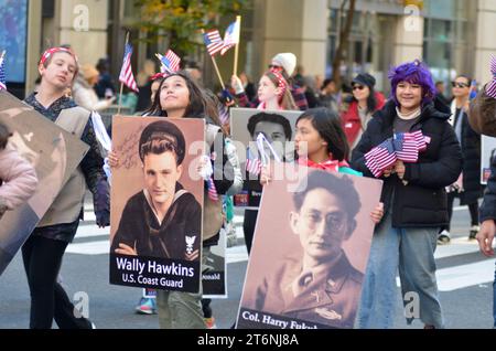 New York City, Usa. November 2023. Die Teilnehmer halten Fotos von verlorenen Soldaten während der jährlichen Veterans Day Parade entlang der 5th Avenue in New York City. Quelle: Ryan Rahman/Alamy Live News Stockfoto