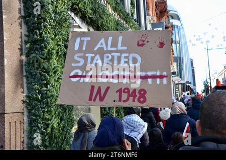 Es begann 1948 Plakat; Szenen aus der Massendemonstration gegen den Krieg pro Waffenstillstand in Zentral-london, die einen Waffenstillstand in palästina israel gaza am 11. november 2023 forderte Stockfoto