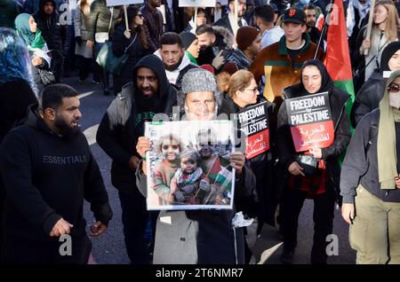 Älterer muslimischer Mann mit Sauerstoffmaske trägt ein Foto von bombardierten palästinensischen Kindern; Szenen aus der Massendemonstration gegen den Krieg pro Waffenstillstand in Zentral-london, die einen Waffenstillstand in palästina israel gaza 11. november 2023 forderte Stockfoto