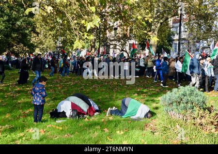 Eine Familie bricht zum Gebet; Szenen aus der Anti-Krieg-Demonstration im Zentrum londons, die einen Waffenstillstand in palästina israel gaza am 11. november 2023 forderte Stockfoto