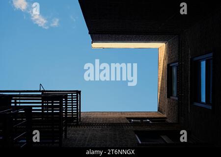 Surreale architektonische Abstraktion des New Yorker Mietshauses, das den blauen Himmel umrahmt Stockfoto