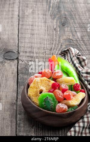 Kandierte Früchte in Holzschale auf rustikalem Hintergrund Stockfoto