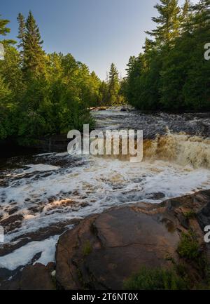 Die unteren Tahquamenon Falls, die durch einen üppig grünen Wald führen Stockfoto