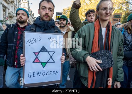 Protest gegen die Bombardierung von Gaza. Ein junger Mann mit einem Plakat "Juden gegen Völkermord" mit einem Davidstern in palästinensischen Farben. 11. November 2023 Stockfoto