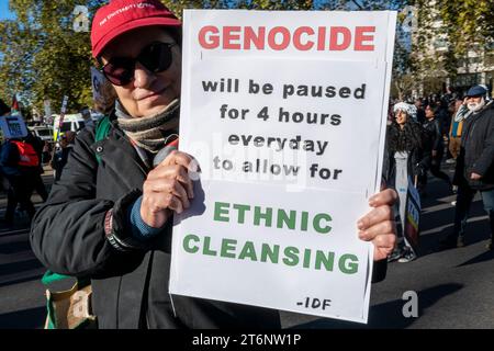 Ein Mann mit einem Plakat "Völkermord wird 4 Stunden am Tag angehalten, um ethnische Säuberungen zu ermöglichen". Protest gegen den Krieg in Gaza. November 2023. Stockfoto