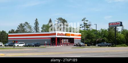 BEMIDJI, MN - 3. JUN 2023: AutoZone Autoteile gewerbliche Gebäude Ladenfassade und Parkplatz mit Fahrzeugen. Stockfoto