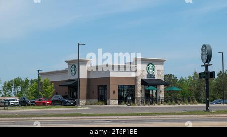 BEMIDJI, MN - 3. JUN 2023: Eigenständiges Starbucks-Café-Gebäude an einem sonnigen Tag, mit Autos in der Fahrspur. Stockfoto