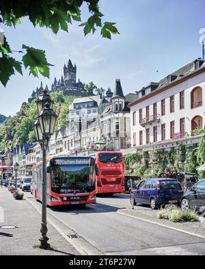 Bus- und PKW-Verkehr auf der Hauptstraße in Cochem mit der Reichsburg hoch über der mittelalterlichen Touristenstadt. Ein muss an der Mosel. Stockfoto