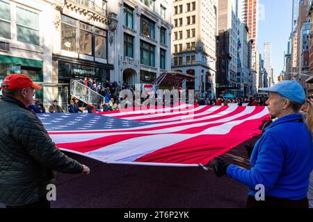 New York City, NY – 11. November 2023. Die jährliche Veterans Day Parade versammelte amerikanische Veteranen, ausländische Veteranen und ihre Anhänger, um die Fifth Avenue hinaufzumarschieren. Die Ground Zero Volunteers-Flagge ist aufgerollt. Stockfoto