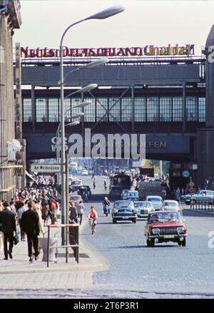 Berlin, Ostberlin GER, Berlin, 20230101, Aufnahme ca. 1976, historische Stadtansicht, in Ostberlin, Foto von der Friedrichstrasse / am Weidendamm, mit dem Bahnhof, Berufsverkehr, Menschen auf den Gehwegen und Autoverkehr auf der Straße, die Richtung S-Bahnhof unterwegs sind, Beschriftung, Werbung mit neuem Deutschland und CRWO, Film aus Wolfen *** Berlin, East Berlin GER, Berlin,20230101, Foto ca 1976, Blick auf die historische Stadt, in Ost-Berlin, Foto der Friedrichstraße am Weidendamm, mit Bahnhof, Rushhour-Verkehr, Menschen auf den Gehwegen und Autoverkehr auf der Straße, Richtung Stockfoto