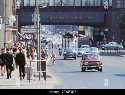 Berlin, Ostberlin GER, Berlin, 20230101, Aufnahme ca. 1976, historische Stadtansicht, in Ostberlin, Foto von der Friedrichstrasse / am Weidendamm, mit dem Bahnhof, Berufsverkehr, Menschen auf den Gehwegen und Autoverkehr auf der Straße, die Richtung S-Bahnhof unterwegs sind, Beschriftung, Werbung mit neuem Deutschland und CRWO, Film aus Wolfen *** Berlin, East Berlin GER, Berlin,20230101, Foto ca 1976, Blick auf die historische Stadt, in Ost-Berlin, Foto der Friedrichstraße am Weidendamm, mit Bahnhof, Rushhour-Verkehr, Menschen auf den Gehwegen und Autoverkehr auf der Straße, Richtung Stockfoto