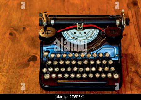 Alte schwarze Schreibmaschine auf einem alten Holztisch Stockfoto