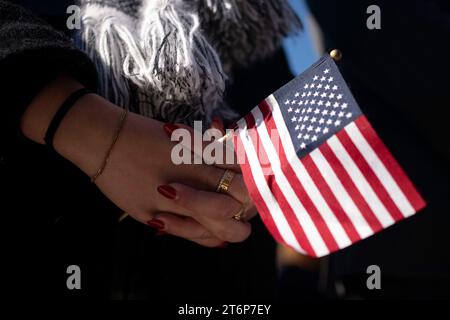 Eine Frau hält eine amerikanische Flagge während einer Gedenkfeier zum National Veterans Day auf dem Arlington National Cemetery in Arlington, Virginia am Samstag, den 11. November 2023. Foto: Bonnie Cash/Pool/SIPA USA Stockfoto