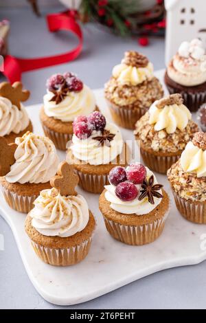 Verschiedene Weihnachts-Cupcakes mit Lebkuchen, gezuckerten Preiselbeeren und kandierten Pekannüssen, bereit für ein Geschenk Stockfoto