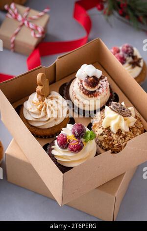 Verschiedene Weihnachts-Cupcakes mit Lebkuchen, gezuckerten Preiselbeeren und kandierten Pekannüssen, bereit für ein Geschenk Stockfoto