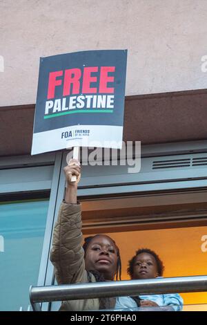 London, Großbritannien. 11. November 2023. Eine Mutter und ein Kind beobachten, wie Hunderttausende palästinensische Unterstützer durch London marschieren Stockfoto