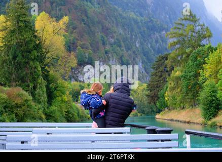 Eine Frau, die ihren kleinen Liebling am 15. Oktober 2023 auf einer Bootsfahrt von Interlaken nach Westen in Richtung Thun-Stadt, Schweiz, umreißt Stockfoto