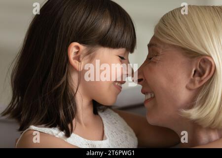 Nahaufnahme glückliche Großmutter und kleine Enkelin, die Nasen berührt Stockfoto