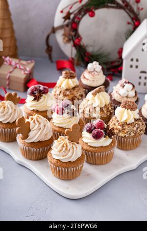 Verschiedene Weihnachts-Cupcakes mit Lebkuchen, gezuckerten Preiselbeeren und kandierten Pekannüssen, bereit für ein Geschenk Stockfoto