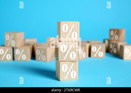 Holzwürfel mit Prozentzeichen auf hellblauem Hintergrund Stockfoto
