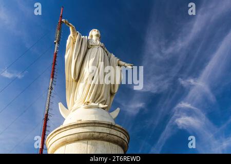 Statue der Jungfrau Maria mit Blick in den Himmel, auf dem Cerro San Cristóbal mit Blick auf die Stadt Santiago, Chile. Stockfoto