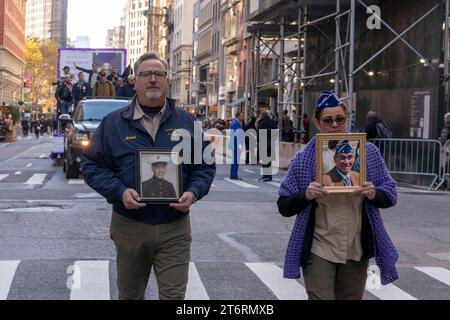 11. November 2023, New York, New York, Vereinigte Staaten: (NEU) Veteran&#39;s Day Parade in New York City. 11. November 2023, New York, New York, USA: Die Teilnehmer halten Fotos einer Veteranin, die an der jährlichen Veterans Day Parade am 11. November 2023 in New York City teilnimmt. Hunderte von Menschen säumten die 5th Avenue, um die größte Veterans Day Parade in den Vereinigten Staaten zu sehen. In diesem Jahr nahmen Veteranen, aktive Soldaten, Polizisten, Feuerwehrleute und Dutzende Schulgruppen an der Parade Teil, die die Männer und Frauen ehrt, die für das Land gedient und geopfert haben Stockfoto