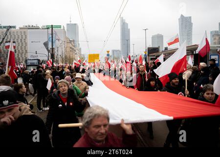 Die Menschen tragen eine riesige polnische Flagge, während sie am 105. Jahrestag der Wiedererlangung Polens in Warschau, Polen, am 11. November 2023 teilnehmen. 105. Polnischer Unabhängigkeitstag in Warschau Copyright: XMarekxAntonixIwanczukx MAI00649 Stockfoto