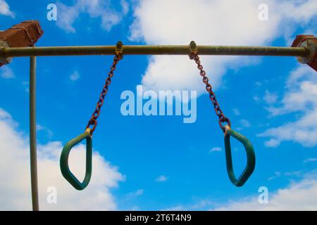 Zwei Trainingsringe hängen an einer Trainingsbar im Freien. Ein dramatischer blau-weißer Himmel im Untergrund. Hochwertige Fotos Stockfoto