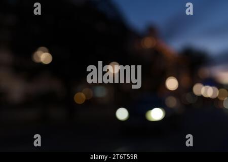 Bokeh Hintergrund von Autos, die nach Sonnenuntergang am Strand entlang fahren, zurück fahren Stockfoto