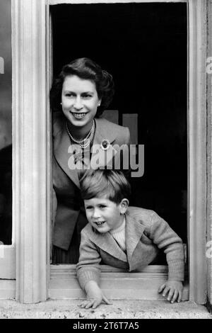 Aktenfoto vom 14./11/52: Prinz Charles hält einen Blick auf seinen vierten Geburtstag, während er sich mit seiner sanft lächelnden jungen Mutter, Königin Elizabeth II., aus einem Fenster beugt Fotos aus jedem Jahr des Königs wurden von der Nachrichtenagentur PA zusammengestellt, um König Karl III. 75. Geburtstag zu feiern. Ausgabedatum: Sonntag, 12. November 2023. Stockfoto