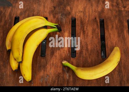 Ein Haufen reifer gelber Bananen auf einer Holzoberfläche. Blick von oben Stockfoto