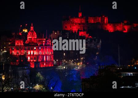 Die Bank of Scotland und Edinburgh Castle werden für die Light Up Red-Kampagne am Waffenstillstandstag im Jahr 2023 in rotem Licht beleuchtet, um den Scottish Poppy Appeal zu unterstützen. Bilddatum: Samstag, 11. November 2023. Stockfoto