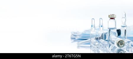 Medizinische Durchstechflaschen zur Injektion mit Spritze und Ampullen auf hellem Hintergrund Stockfoto