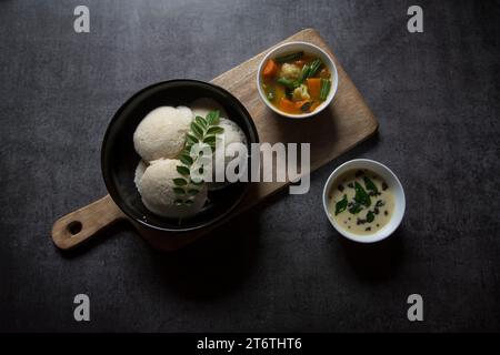 Beliebte südindische Snacks idli Sambar oder idly Sambhar, zubereitet durch Dämpfen fermentierten Reis und serviert mit Kokos-Dip und Gemüsesuppe oder Sambar. Stockfoto