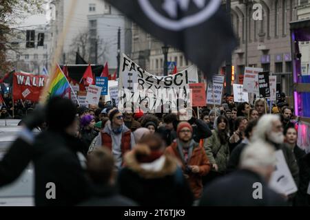 Die Teilnehmer des antifaschistischen Protestes "für Ihre und unsere Freiheit" halten Fahnen und Plakate und marschieren entlang der Marzalkowska-Straße. Der antifaschistische Protest "für deine und unsere Freiheit" fand auf den Straßen von Warschau am 11. November 2023 am polnischen Unabhängigkeitstag statt. Hunderte von Menschen mit Plakaten und Fahnen nahmen an der Veranstaltung Teil, gesichert durch die Polizei. Laut den Organisatoren ist diese Form des Feierns am 11. November der beste Ausdruck der Verbundenheit mit der Idee einer lebendigen, vielfältigen und wahren Unabhängigkeit. Stockfoto