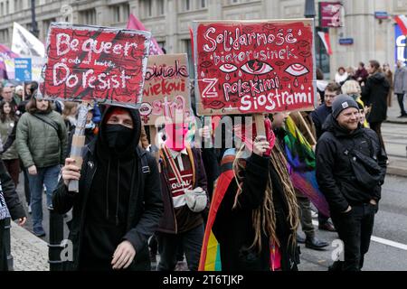 Teilnehmer des antifaschistischen Protestes "für Ihre und unsere Freiheit" halten am polnischen Unabhängigkeitstag Plakate mit Slogans wie "sei queer, Do Resist" und "Solidarität der belarussischen Frauen mit polnischen Schwestern". Der antifaschistische Protest "für deine und unsere Freiheit" fand auf den Straßen von Warschau am 11. November 2023 am polnischen Unabhängigkeitstag statt. Hunderte von Menschen mit Plakaten und Fahnen nahmen an der Veranstaltung Teil, gesichert durch die Polizei. Laut den Organisatoren ist diese Form des Feierns am 11. November der beste Ausdruck der Verbundenheit mit der Idee eines lebendigen, vielfältigen und wahrhaft eigenständigen Lebens Stockfoto