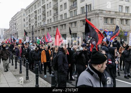 Teilnehmer des antifaschistischen Protestes "für Ihre und unsere Freiheit" halten Fahnen und Plakate entlang der Marzalkowska-Straße. Der antifaschistische Protest "für deine und unsere Freiheit" fand auf den Straßen von Warschau am 11. November 2023 am polnischen Unabhängigkeitstag statt. Hunderte von Menschen mit Plakaten und Fahnen nahmen an der Veranstaltung Teil, gesichert durch die Polizei. Laut den Organisatoren ist diese Form des Feierns am 11. November der beste Ausdruck der Verbundenheit mit der Idee einer lebendigen, vielfältigen und wahren Unabhängigkeit. Stockfoto