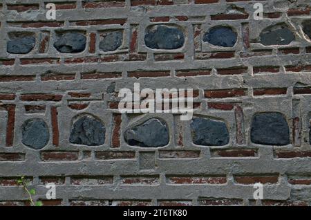 Natürliches Muster für Hintergründe und Tapeten durch die Dekoration einer roten Ziegelwand mit Steinblöcken, die mit Beton befestigt sind, Dragalevski Kloster Stockfoto