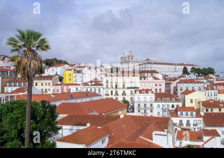 PRODUKTION - 26. Oktober 2023, Portugal, Lissabon: Hinter zahlreichen Häusern im Stadtteil Alfama erhebt sich das Kloster Sao Vicente de Fora auf einem Hügel mit einer Palme auf der linken Seite. Foto: Viola Lopes/dpa Stockfoto