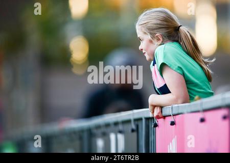 Ein junges Mädchen, Dulwich Hamlet, das einen rosa-blauen Schal trägt, beobachtet die Damenmannschaft im Champion Hill Stadion Stockfoto