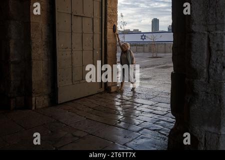 Am Sabbattag klopft eine Frau am Eingang zum Jaffa-Tor in der Altstadt von Jerusalem Jerusalem. Jerusalem ist eine heilige Stadt für drei monotheistische Religionen: Judentum, Christentum und Islam. Diese religiöse Vielfalt hat zu einem Zusammenleben geführt, das sowohl freundlich als auch auffällig ist, obwohl die Situation seit den Anschlägen vom 7. Oktober 2023 etwas angespannt geworden ist. Trotz der Konflikte, die die Geschichte der Stadt geprägt haben, haben die Bewohner Jerusalems gelernt, in Harmonie zusammenzuleben. Dies spiegelt sich im Alltag wider, in dem die drei Religionen öffentliche Räume teilen, wie das Alte C Stockfoto