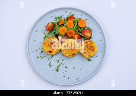 Eine bunte Auswahl an verschiedenen Gerichten wird auf einem weißen Teller mit einer Auswahl an Gemüse, Proteinen, Körnern und anderen Gerichten serviert Stockfoto