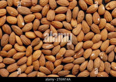 Eine hölzerne Schüssel gefüllt mit verschiedenen Nüssen mit weißem Salz auf ihrer braunen Haut Stockfoto