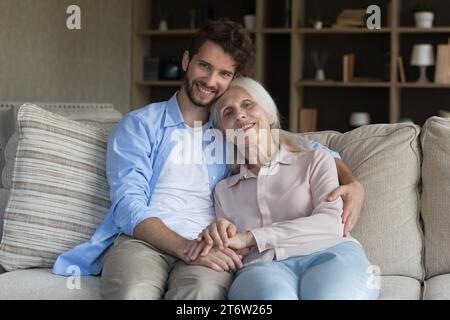 Glückliche alte Mutter und erwachsener Sohn entspannen sich auf dem Sofa Stockfoto