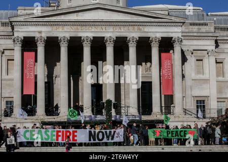 Große Banner mit den Aufschriften „Frieden“ und „Waffenstillstand jetzt“ bilden den Hintergrund für den Schuhprotest. XR-Familien organisierten den Schuhprotest, um den Tod von Kindern in Gaza zu veranschaulichen. Sie fordern einen sofortigen Waffenstillstand im Krieg zwischen Israel und der Hamas. Tausende von Kindern wurden getötet, seit Israel Vergeltungsmaßnahmen gegen die Hamas ergriffen hat, nachdem sie über 1000 Israelis getötet und 220 Geiseln genommen hatten. Stockfoto