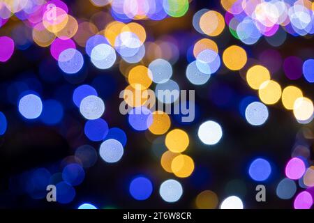 Bokeh der bunten Neujahrslichter bei Nacht. Hintergrundbild. Neujahrsbeleuchtung Stockfoto