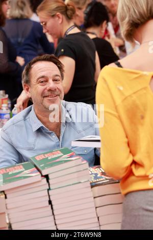 Brive-la-Gaillarde, Frankreich. November 2023. Michel Bussi widmet seine Bücher auf der berühmten Brive Book Fair (Foire du livre de Brive). Michel Bussi hat eine literarische Karriere von großer Bedeutung, insbesondere auf dem Gebiet der Kriminalromane. Er ist einer der meistverkauften französischen Schriftsteller. Michel Bussis Romane werden in mehr als 35 Sprachen übersetzt und sind besonders beliebt in Großbritannien, Italien, China, Brasilien, Russland... Brive-la-Gaillarde, Corrèze, Frankreich, Europa. Foto HM Images/Alamy Live News. Stockfoto