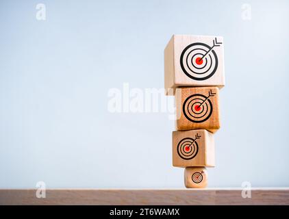 Großes Zielsymbol oben auf kleinerem Bullseye-Symbol auf Holzwürfelblöcken stapeln sich isoliert auf weißem Hintergrund mit Kopierraum. Ziel und Erfolg, effo Stockfoto